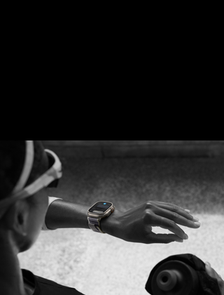 Una jogger che guarda il suo Apple Watch Ultra 2 sul polso sinistro, facendo il gesto doppio tap con l’indice e il pollice della mano sinistra