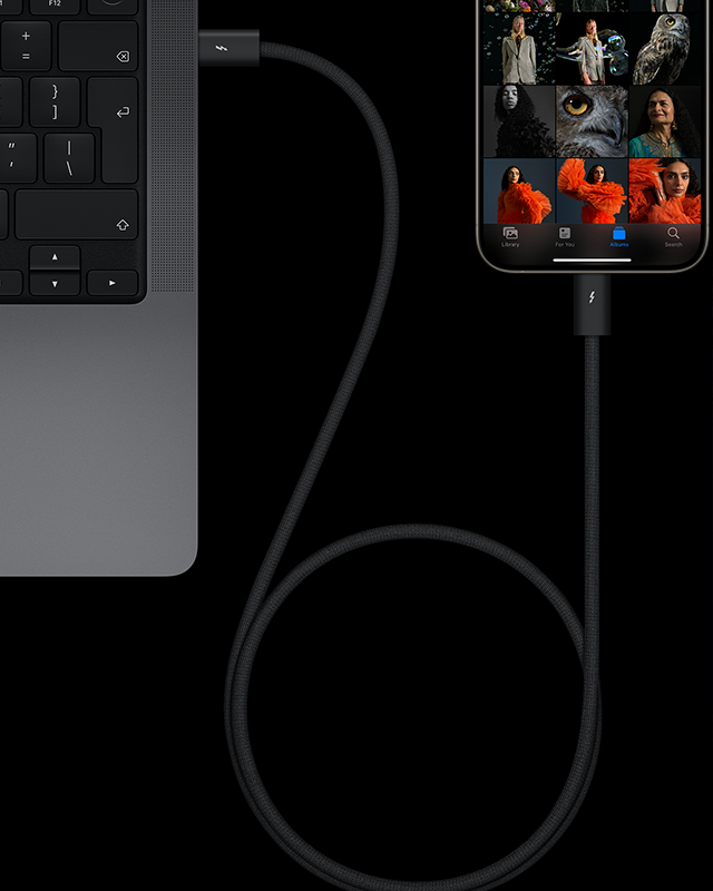 A Natural Titanium colour iPhone 15 Pro with artistic portrait photos in a camera roll connected to a MacBook Pro by a USB-C cable